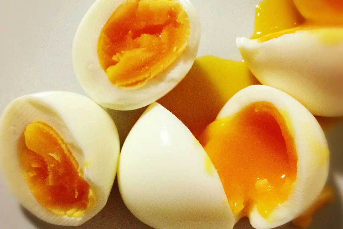 Halved jammy eggs with thick, glossy orange yolks